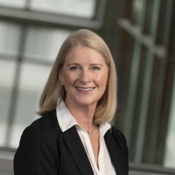 Beth Allgaier Headshot in black blazer and white shirt