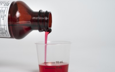 Liquid medicine being poured into a dosing cup