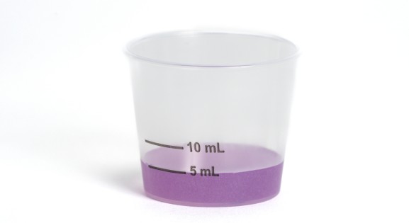 Dosing cup with purple liquid medicine