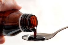 Bottle of Dextromethorphan being measured into spoon