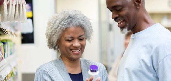 Seniors reading medicine bottle labels in pharmacy