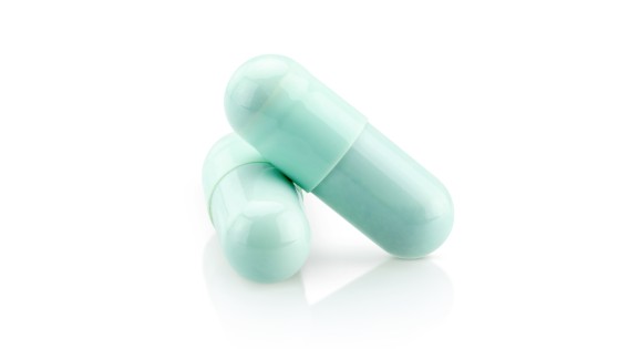 blue green capsules on white background