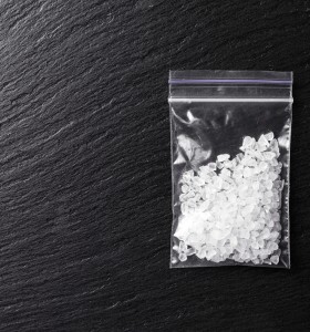 meth crystals in a plastic bag on a dark background