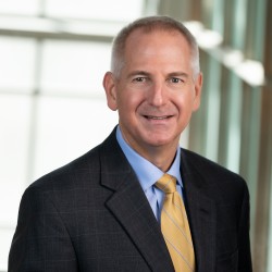 Brian Green Headshot in suit and yellow tie