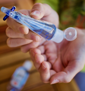 woman using travel sized hand sanitizer